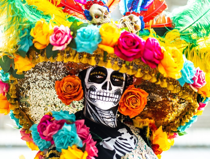 Person with face paint wearing a hat with flowers. Photography. 